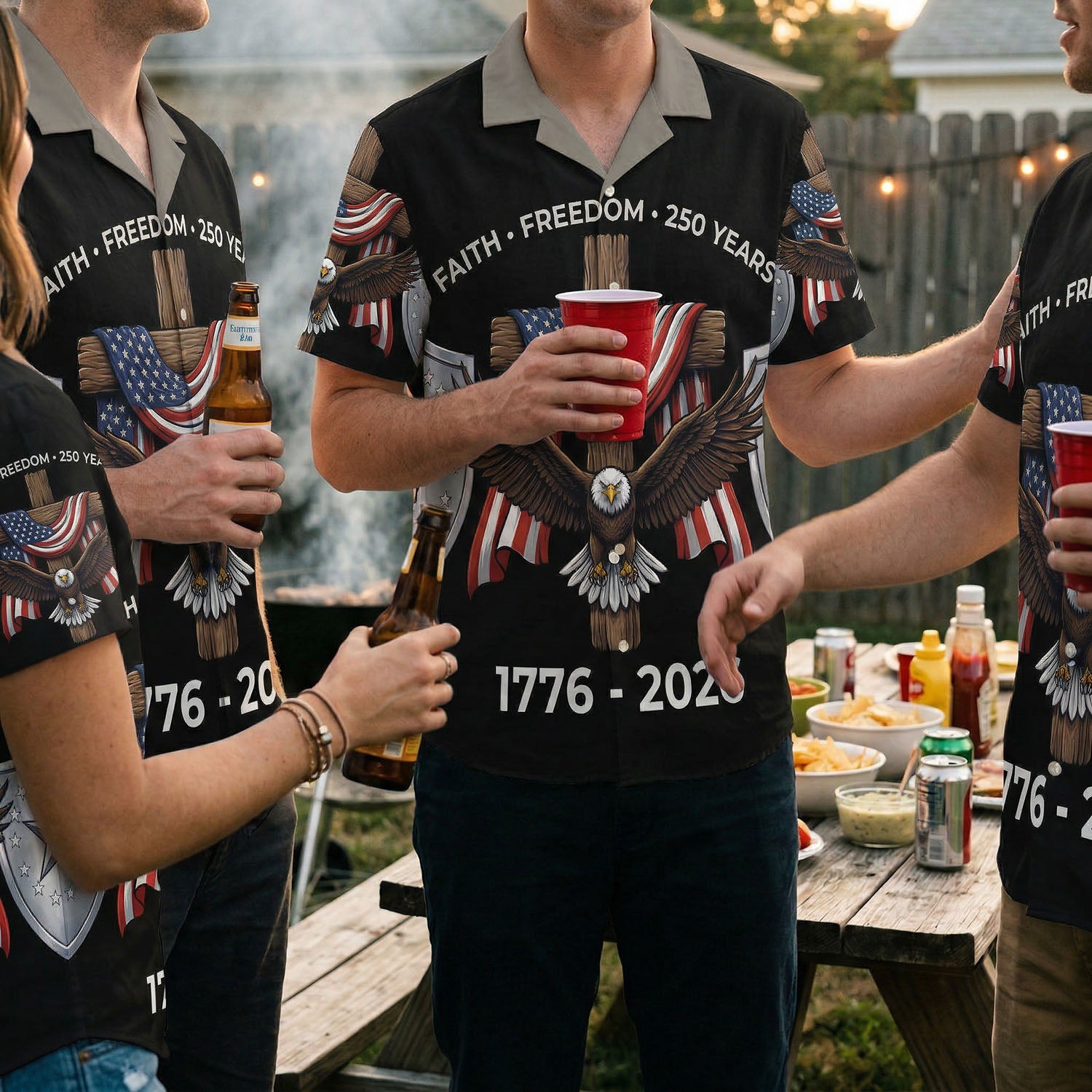 Lifestyle photography of patriots at a BBQ event wearing the black commemorative anniversary shirt, emphasizing community and national pride.