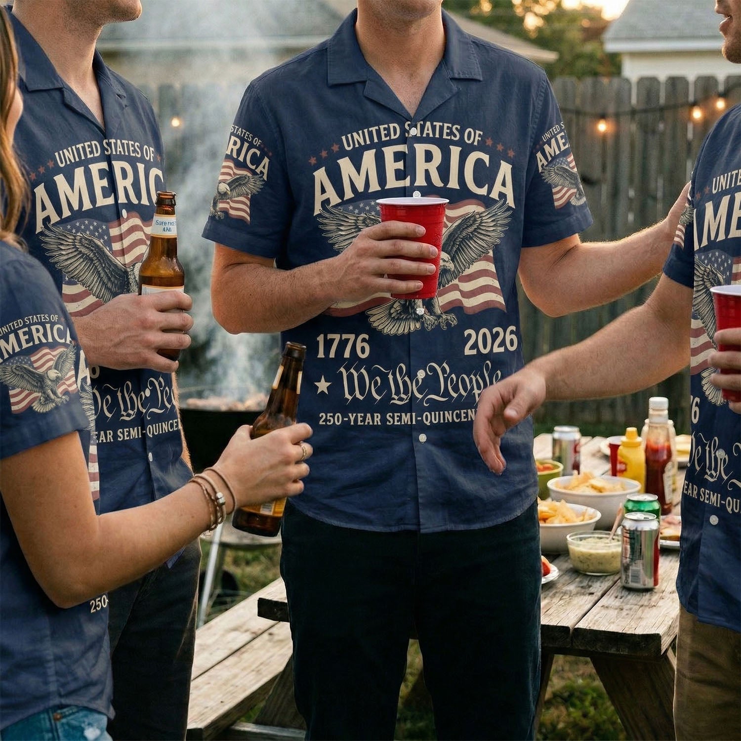 A group of friends wearing matching We The People patriotic shirts at a backyard BBQ celebration for the US 250th anniversary