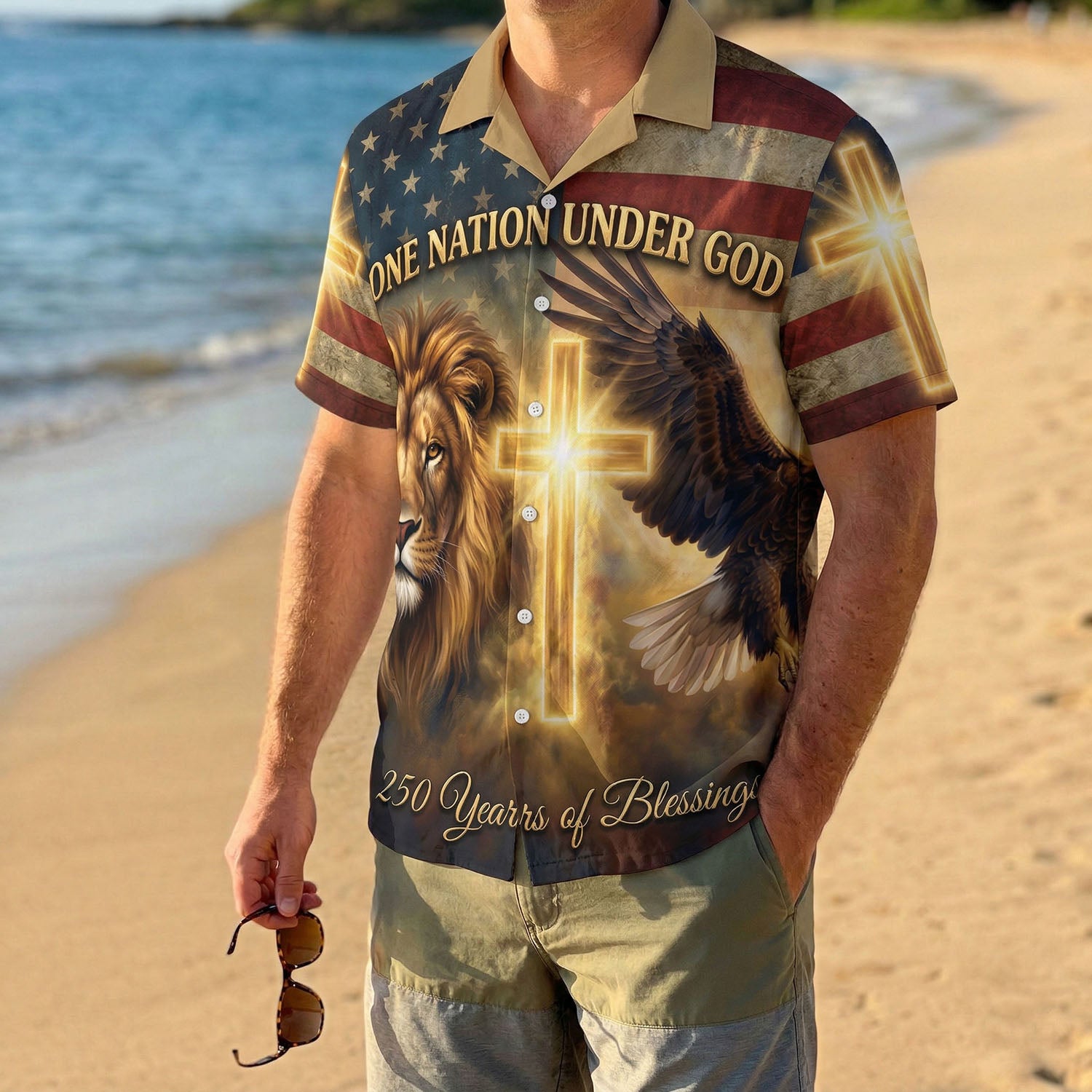 A male model wearing the One Nation Under God Aloha shirt on a sunny beach, showcasing a powerful faith-based summer holiday style.