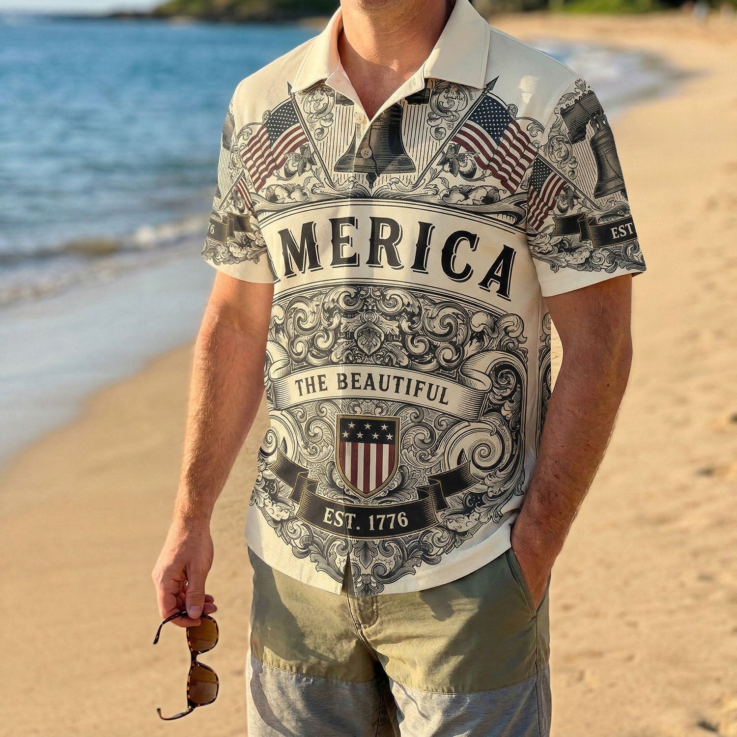 A male model wearing the vintage cream Liberty Bell patriotic shirt at a sunny beach showcasing a classic American summer look for the 250th anniversary