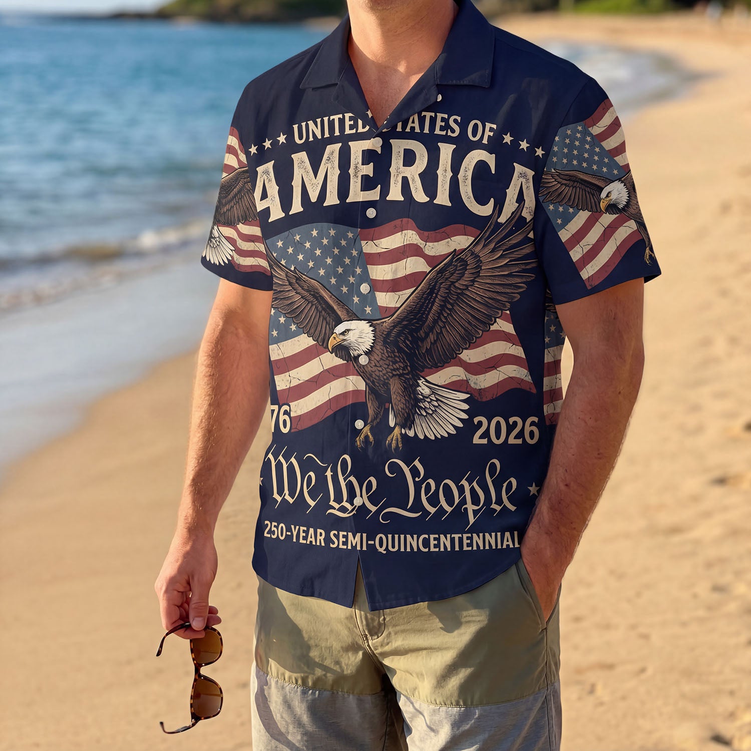 A male model wearing the vintage America The Beautiful Liberty Bell shirt on a sunny beach showcasing a classic American summer outfit