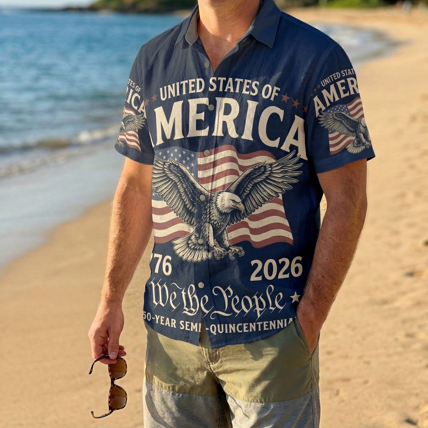 A male model wearing the navy blue We The People patriotic shirt on a sunny beach showcasing a classic American summer look