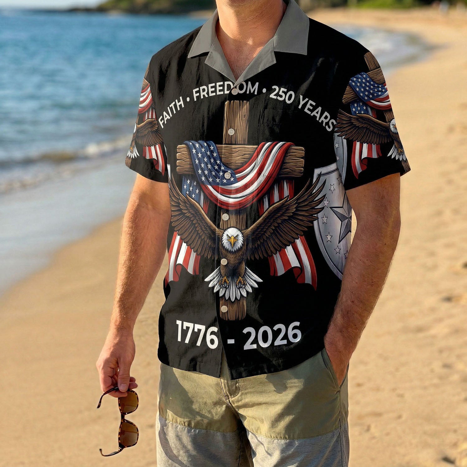 A man wearing the black Faith and Freedom eagle shirt on a sunny beach, showcasing a bold and proud American summer look.
