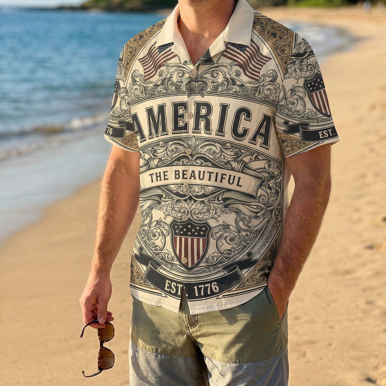 A male model wearing the vintage America The Beautiful Liberty Bell shirt on a sunny beach showcasing a casual patriotic summer outfit
