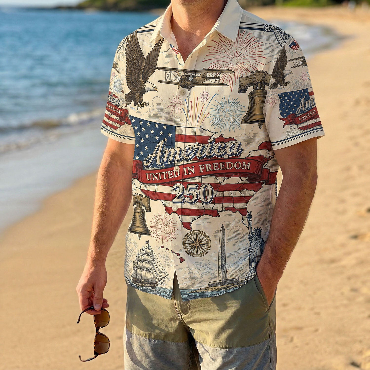 A male model wearing the vintage America The Beautiful Liberty Bell shirt on a sunny beach showcasing a classic American summer outfit