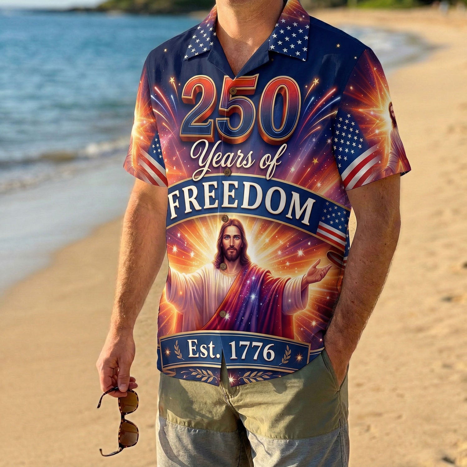 A man wearing the vibrant navy 250 years of freedom Jesus shirt on a beach, showcasing a festive patriotic summer look.