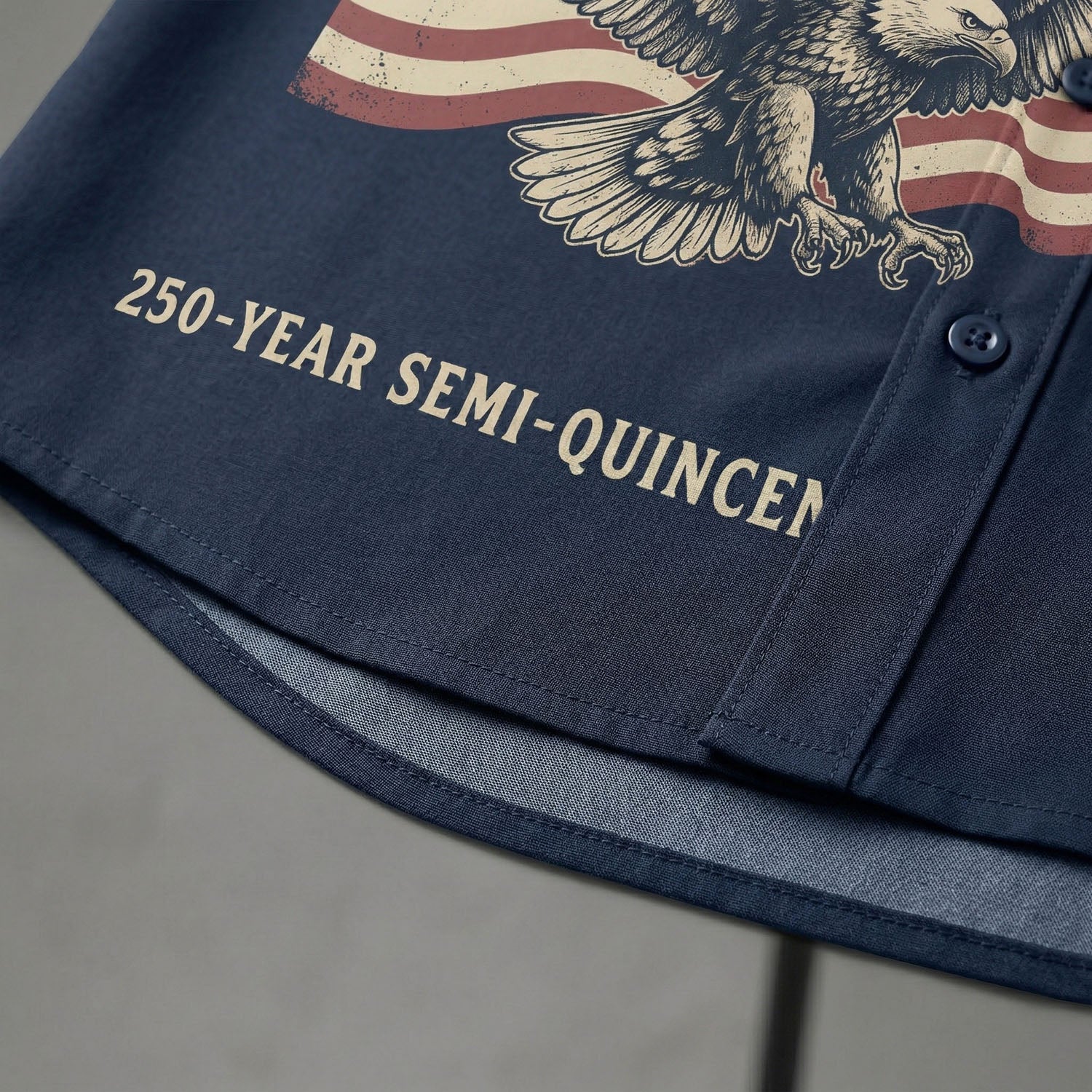 Macro close up of the high quality print showing the 250 Year Semi Quincentennial text and patriotic banner on the navy blue Aloha shirt