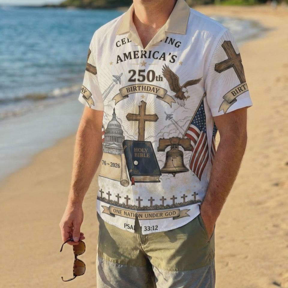 A male model wearing the One Nation Under God 1776-2026 commemorative shirt on a sunny beach, showcasing a faith-based patriotic look.