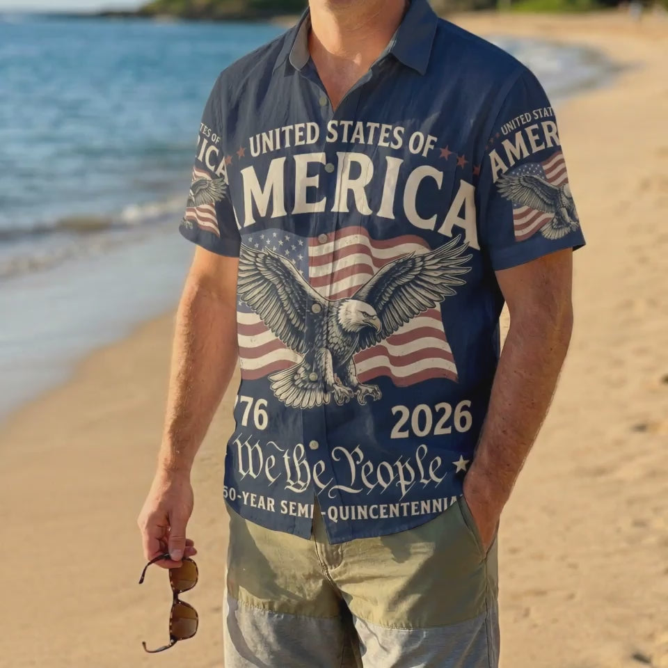 A male model wearing the navy blue We The People patriotic shirt on a sunny beach showcasing a classic American summer look