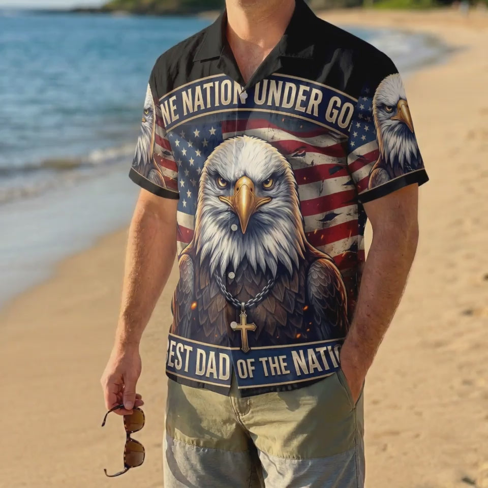 A male model wearing the black One Nation Under God religious shirt on a sunny beach showcasing a patriotic Father's Day summer gift look